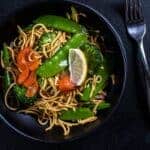 Filipino Vegetable Pancit in a black bowl with a fork